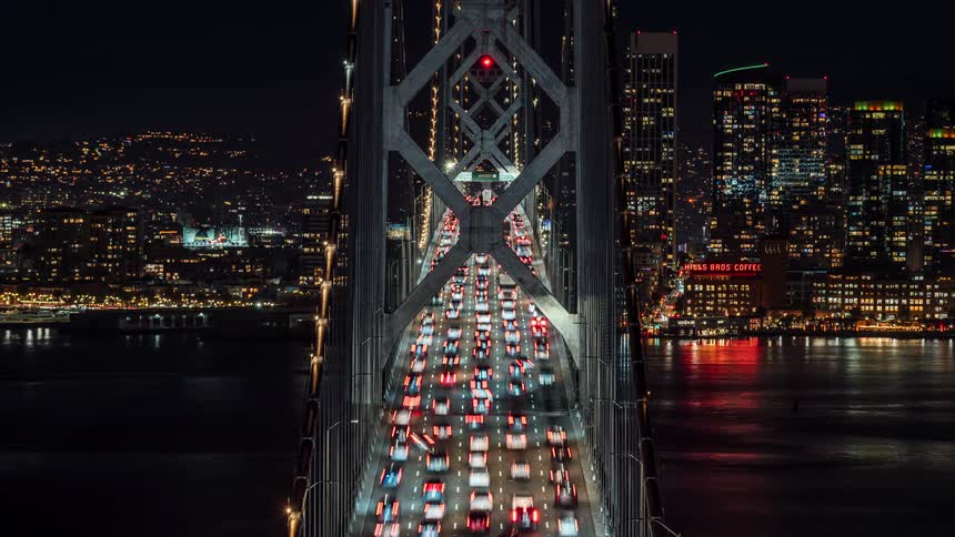 Heavy traffic moves towards the bright city at night