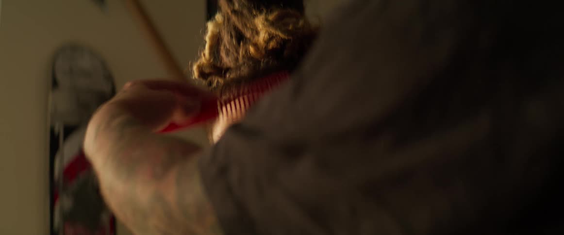 Man cutting another mans hair with a razor