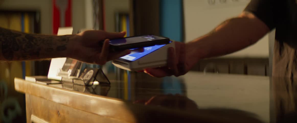 A customer pays his bill with a phone