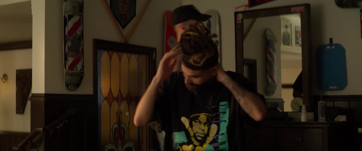 A barber finishes cleaning off a client and they both walk around the chair