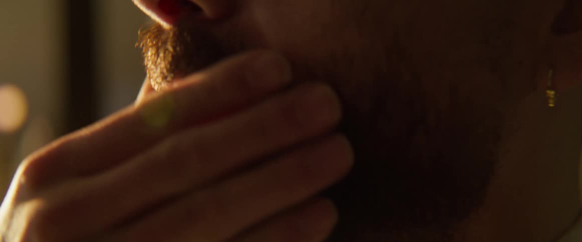 Man smooths down his mustache and beard