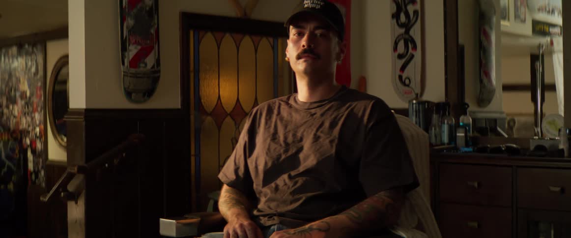 A barber is sitting in his shop