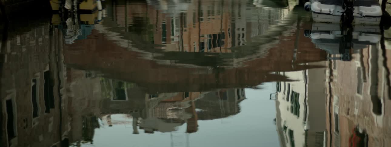 A view of some water with the reflection of buildings
