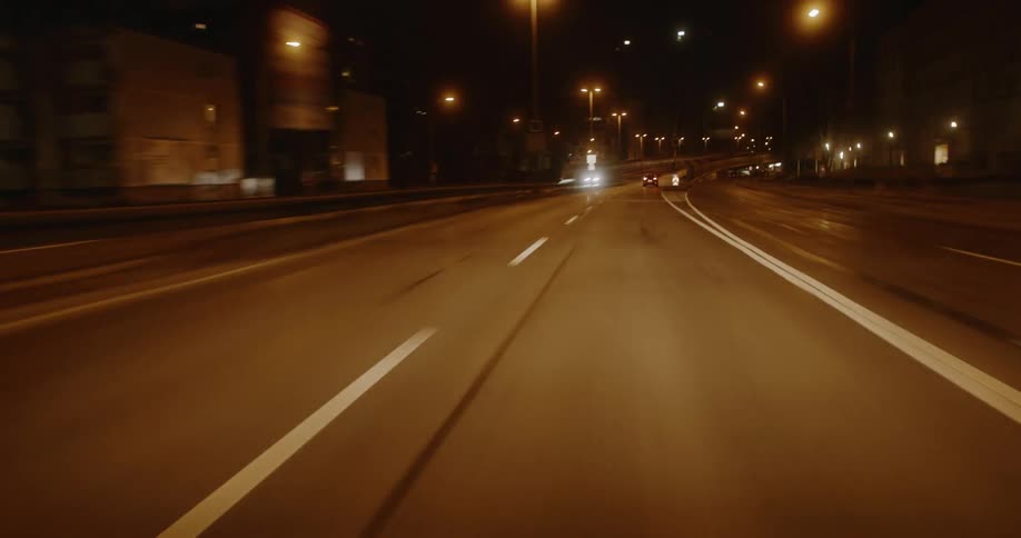 Cars are driving at night on the highway