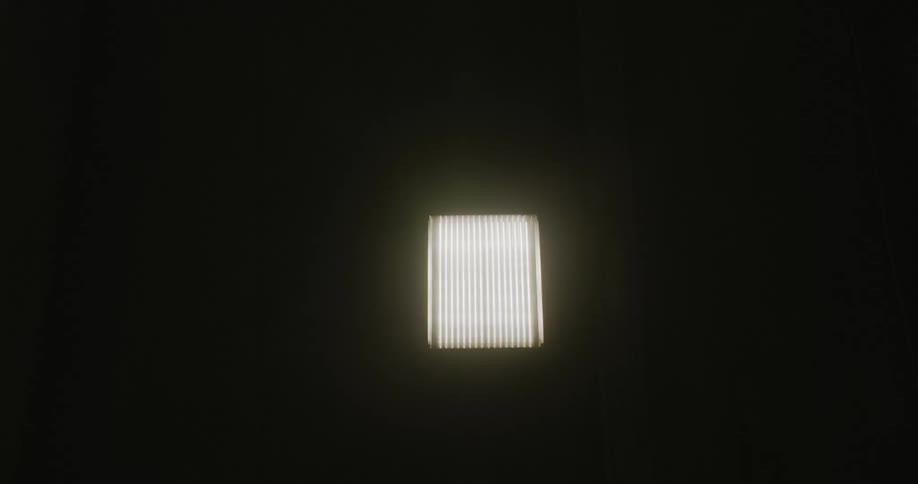 The tunnel is dark with lights on the ceiling