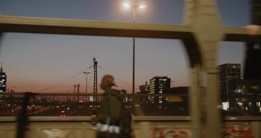 The camera is panning across the city skyline from a moving object on a bridge