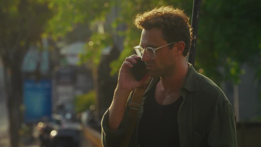 A man talks on his cell phone on a sunny day