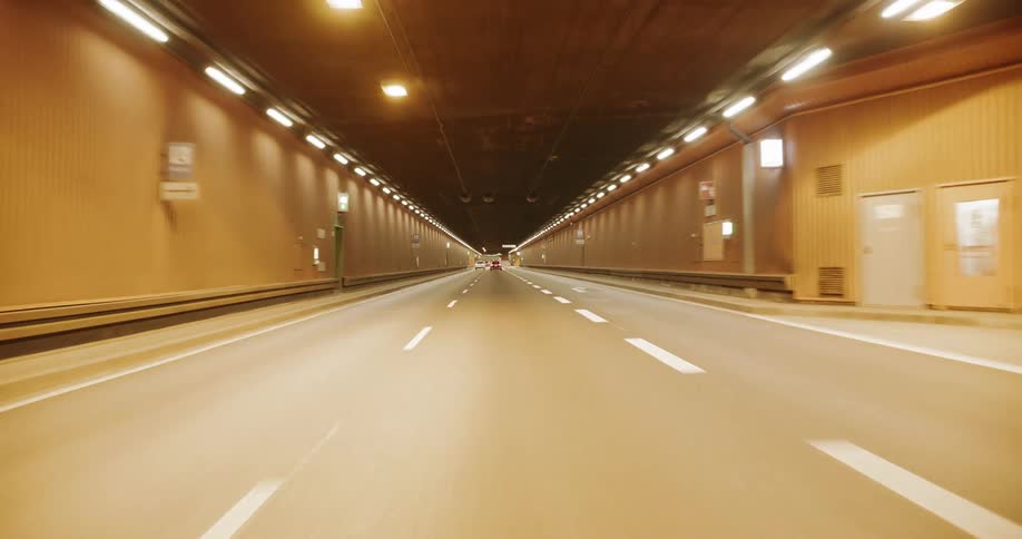 A car drives down the long road in the tunnel