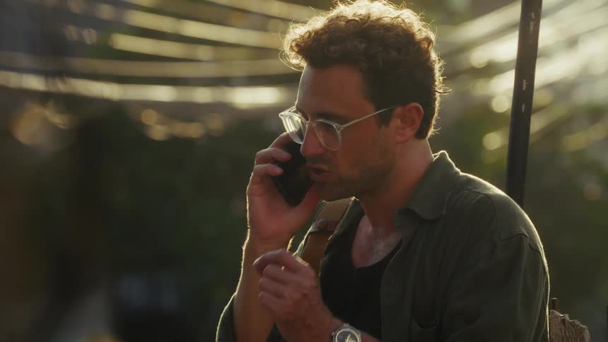 Man anxiously talks to someone on his smart phone outdoors
