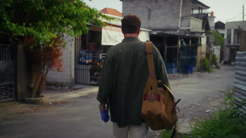 A man walks by the scooters going down the road