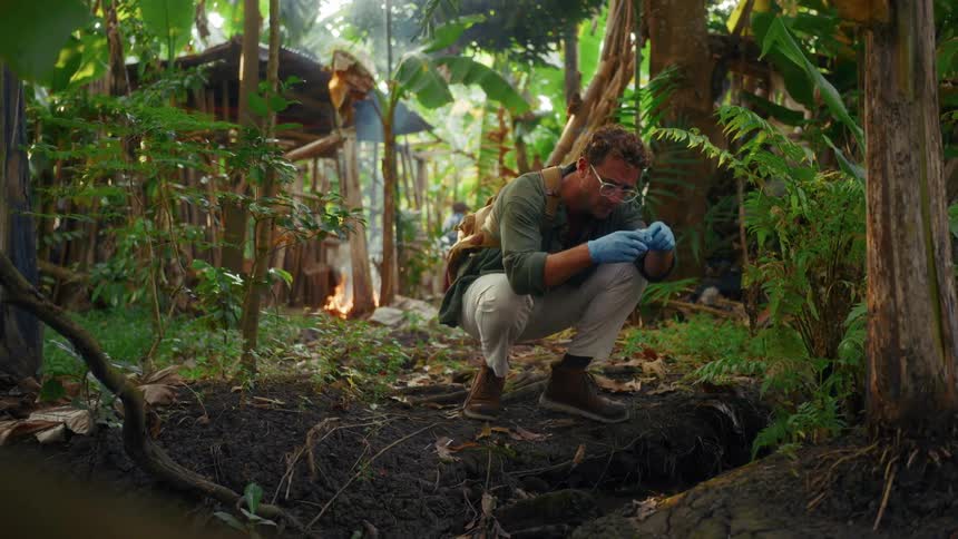 Man taking natural samples in the middle of a forest