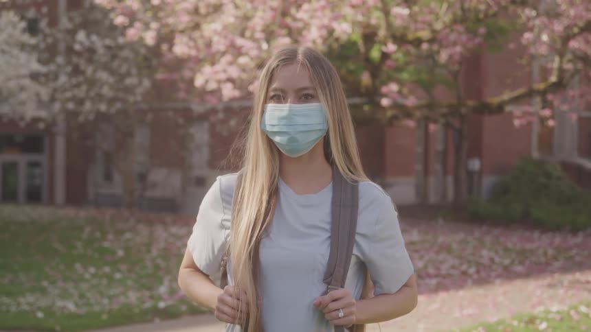Girl with a mask in a field of cherry trees