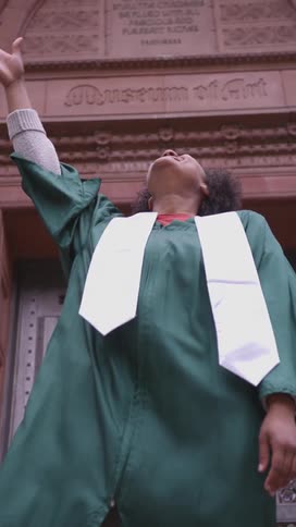 A graduate tosses their cap up in the air