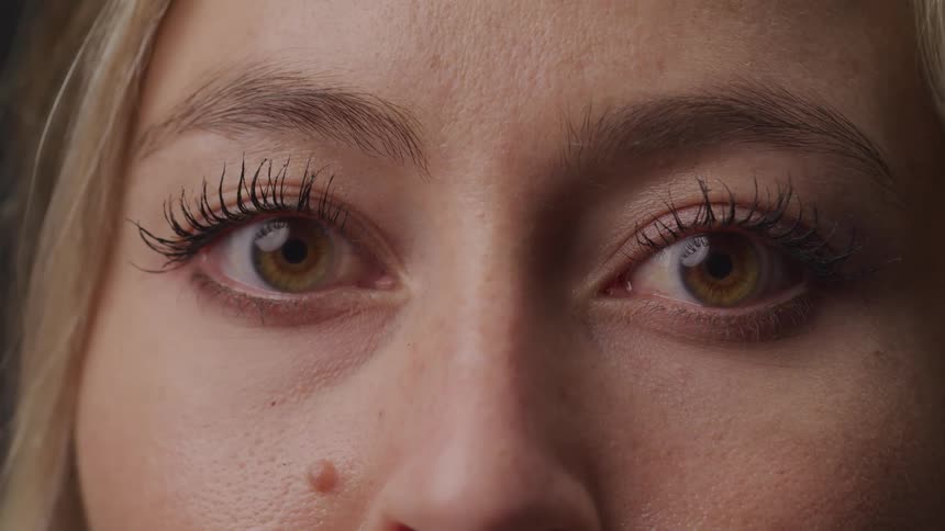 The camera is pointed directly at the woman brown eyes and long beautiful eye lashes