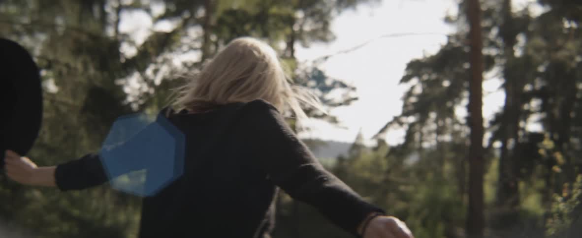 A woman is dancing outside in the forest