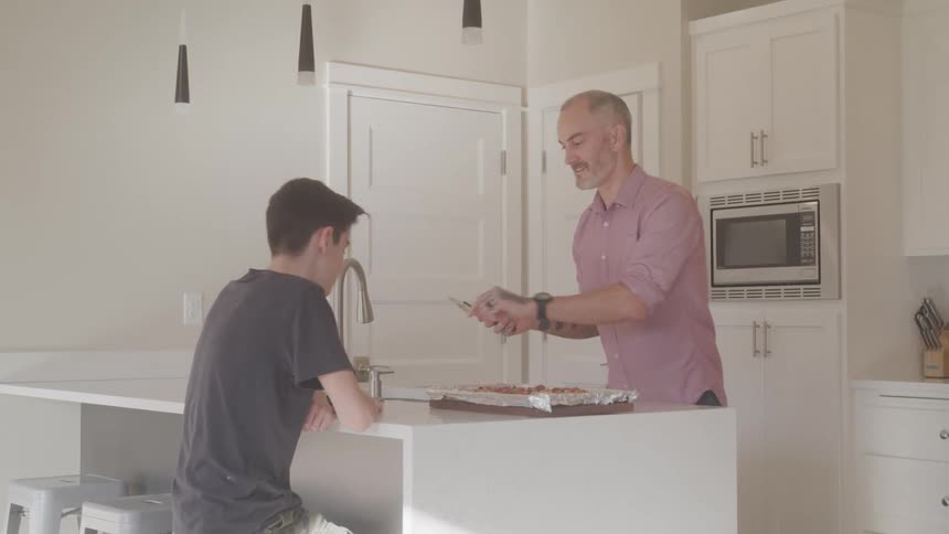 A man cuts food in the kitchen