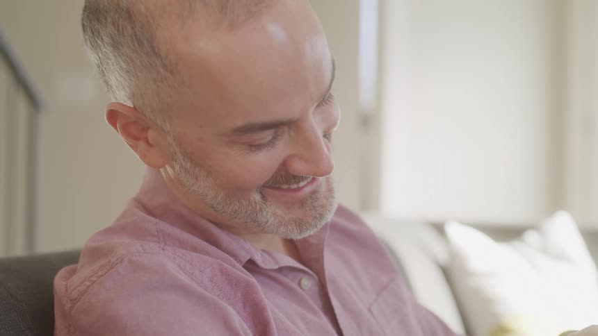 A man is smiling on the couch