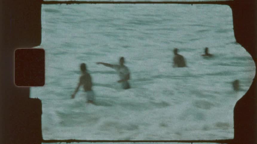 A group of friends playing on the beach at the shoreline