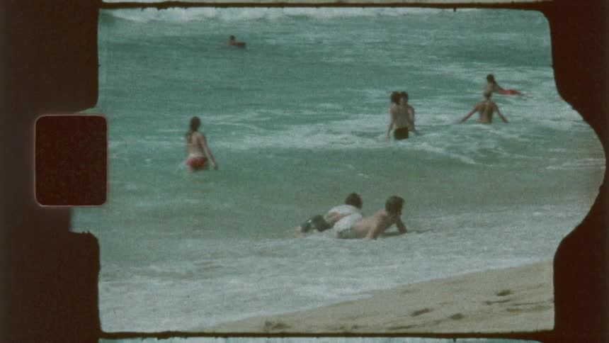 A group of people wading and playing in the ocean waves