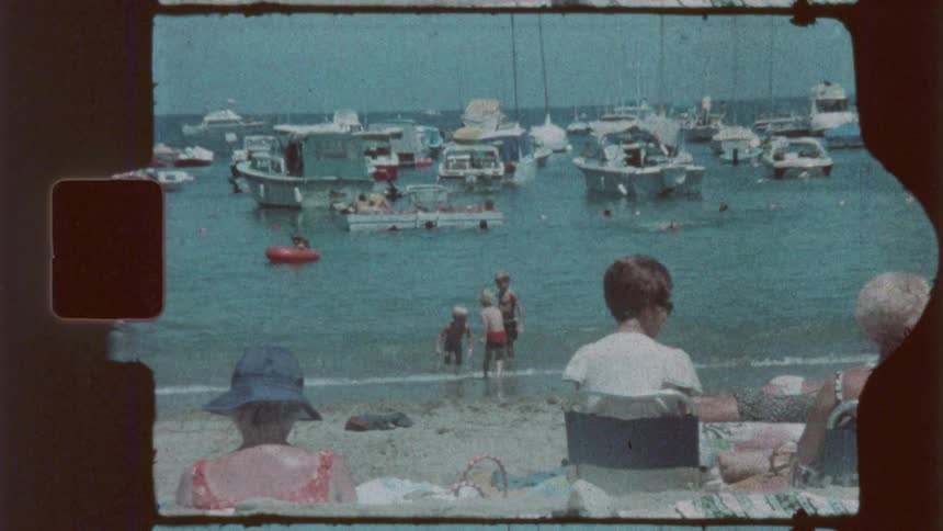 Parents watch their children play on the beach