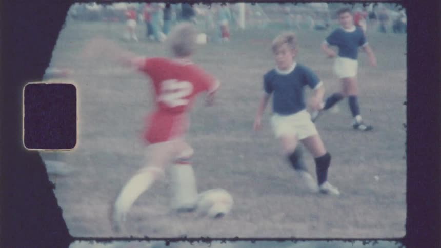 Vintage footage of a boys soccer game in the afternoon