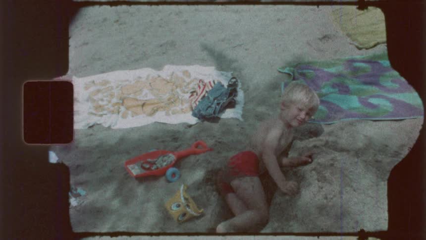 A boy is digging in the sand