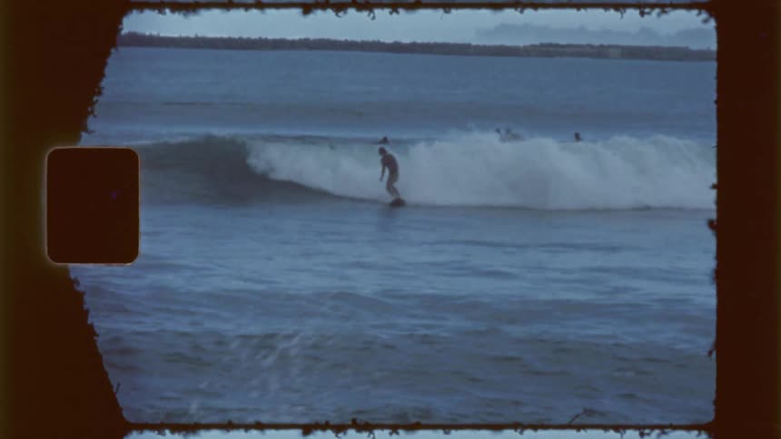 Men are surfing waves by the shore