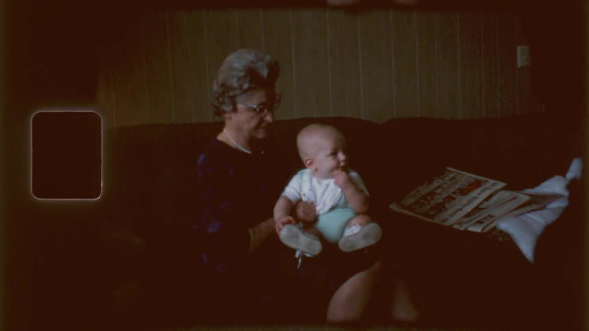 A baby is sitting on his grandmothers lap