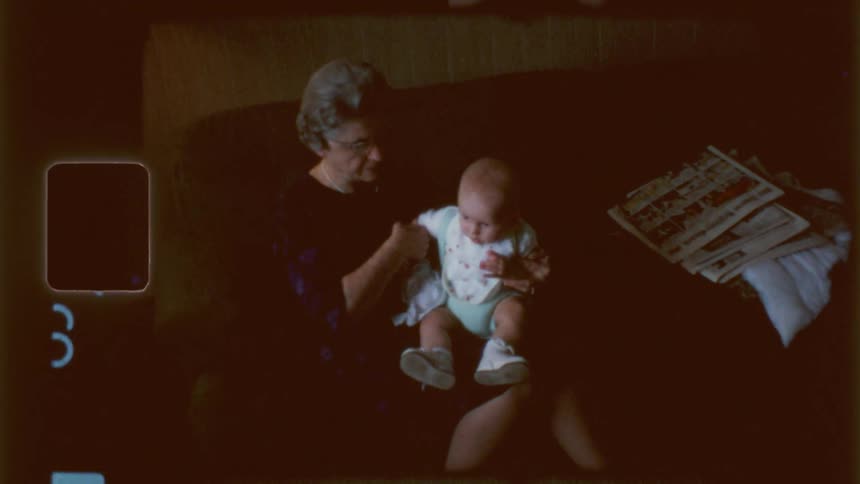 A grandmother holds her grandson on the couch