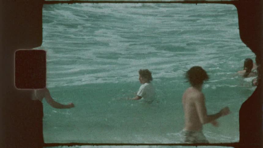 People are splashing and swimming on the beach