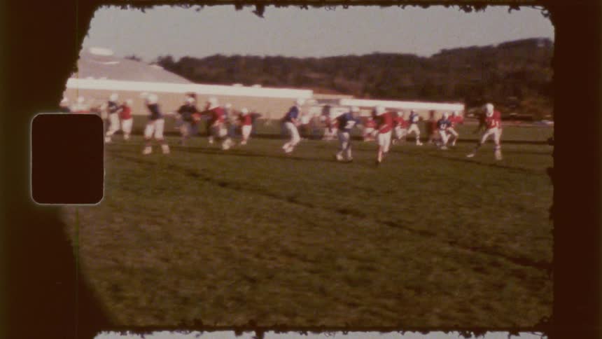 Boys playing rugby in a field