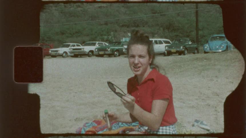 Girl taking off her sunglasses on the beach