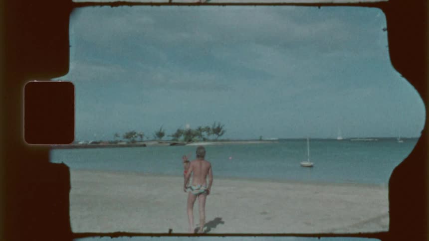 Two young men play with a ball on the beach on a cloudy summer day