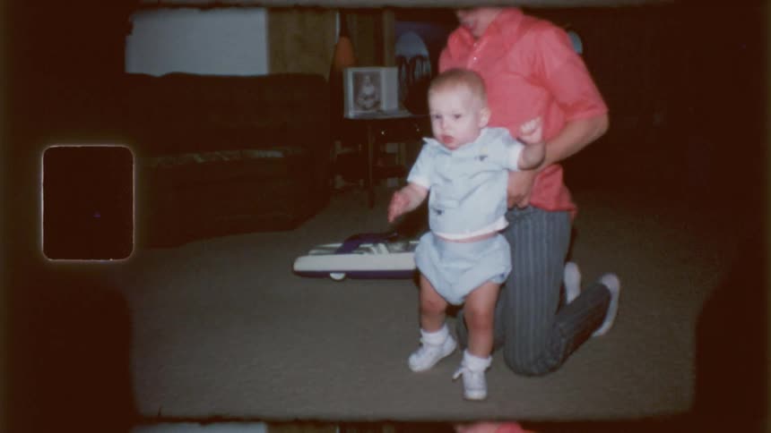 A teenager helps a baby walk