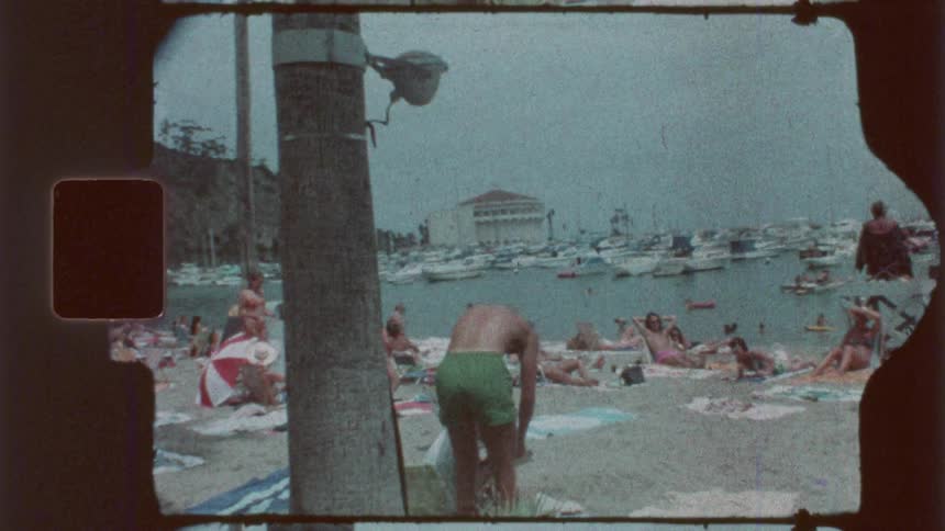 Boy digging in the sand is among those enjoying a beach near the marina on a summer day
