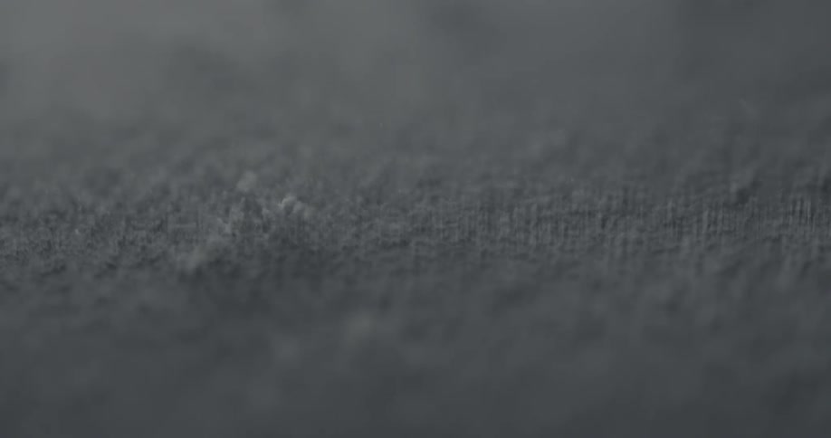 Clumps of a powdery substance roll across a fabric surface