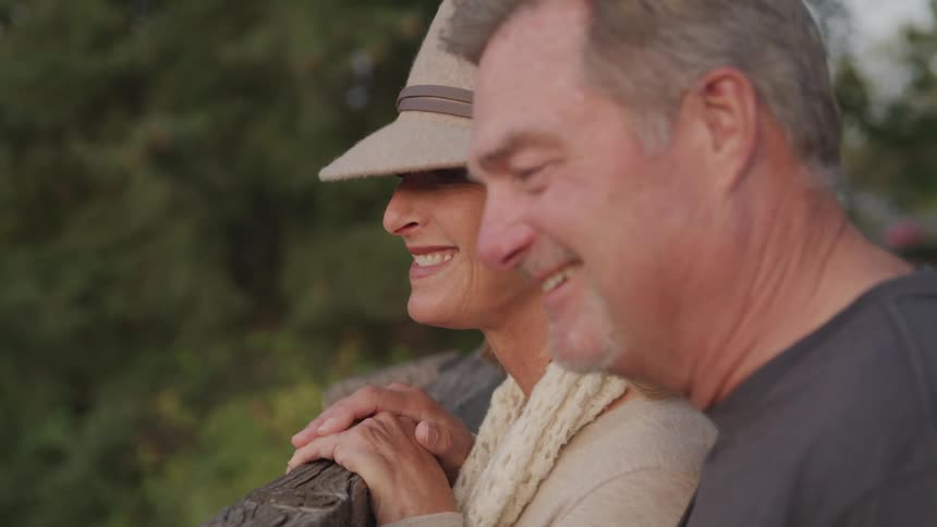 A man and woman smile while looking at nature