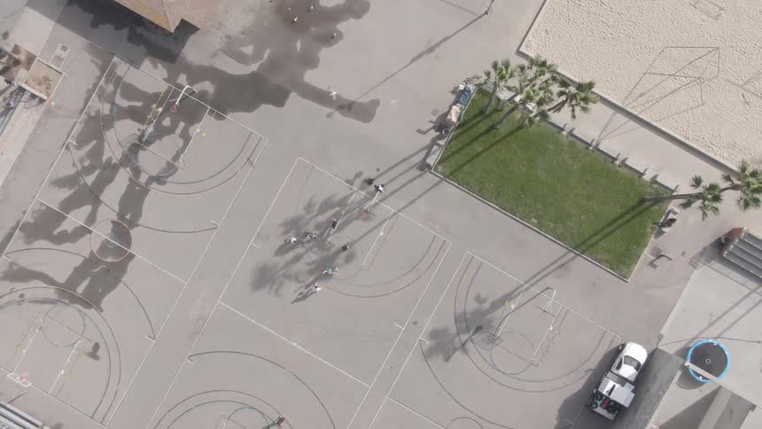 People playing on the basketball court with a sandpit nearby