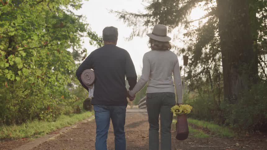A man and woman look like they are walking to have a picnic