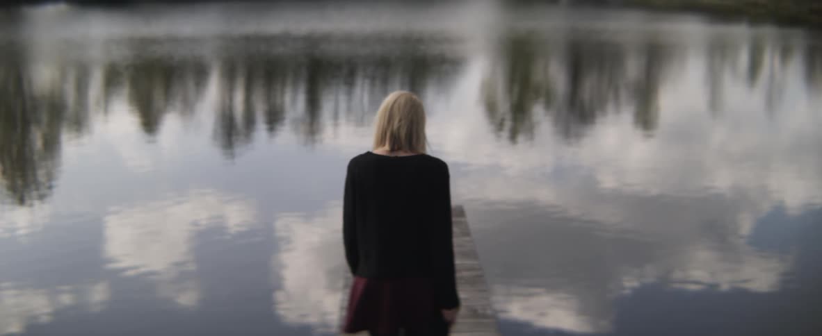 A woman is walking down the wooden pier
