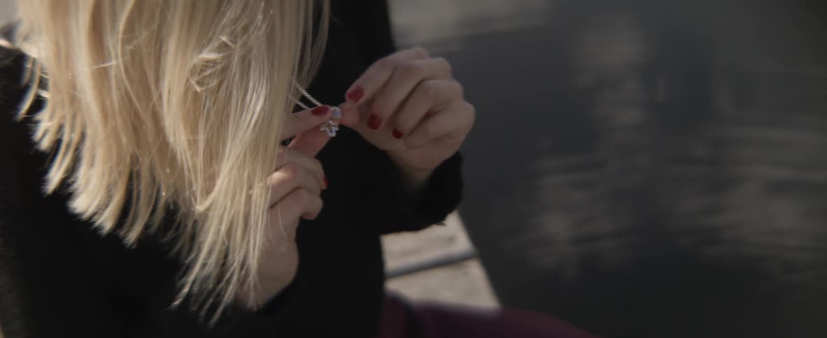 A woman examines her necklace