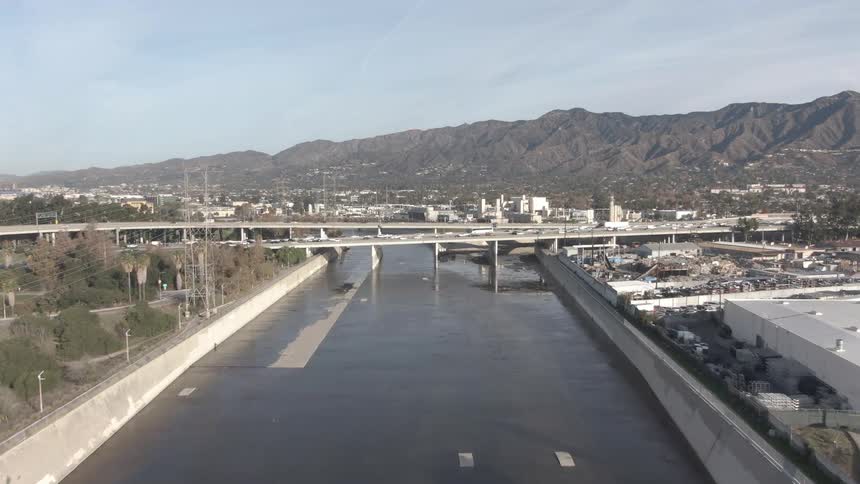 Bridges cross a river in front of a city at the base of a mountain