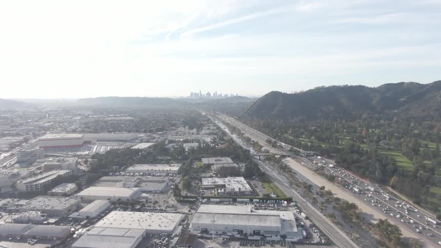 A busy freeway divides a city from the mountains
