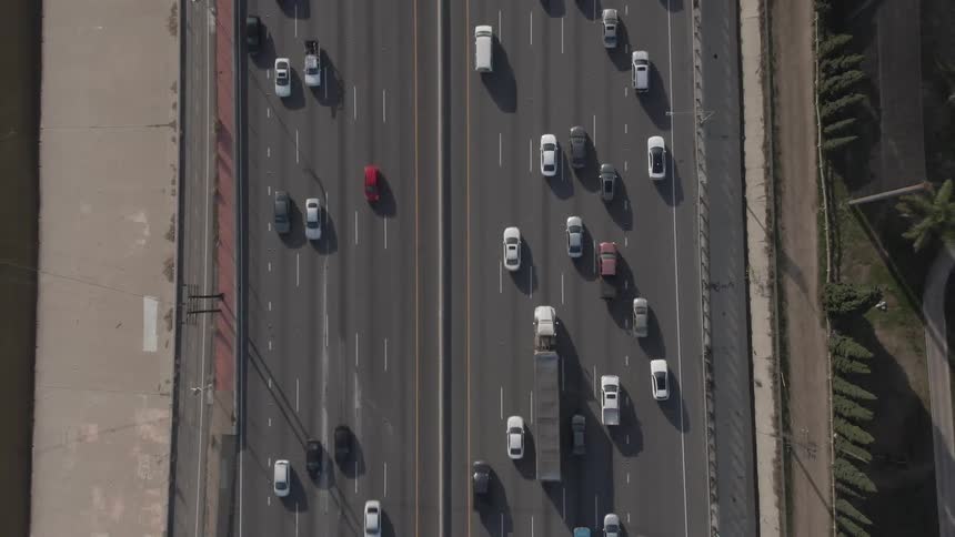 Aerial view of cars and trucks traveling along a multi lane highway with the roadway markings clearly visible