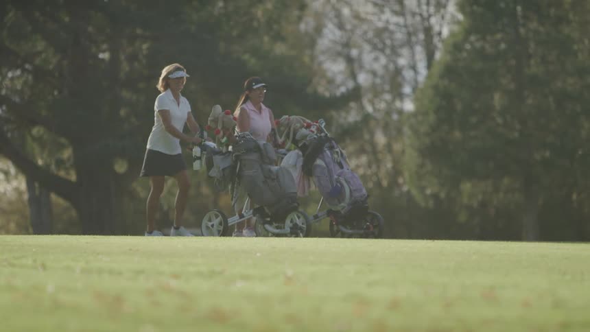 A footage of golfers walking the grassland