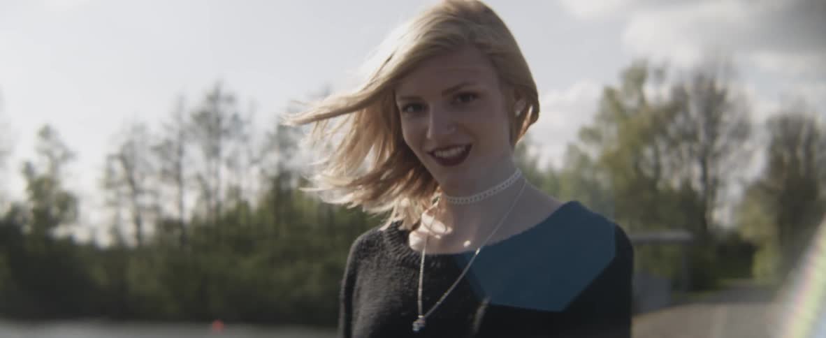 A woman smiling as she walks across the grass