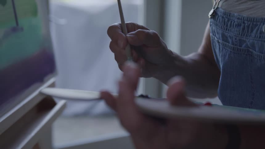 A woman is painting on a canvas