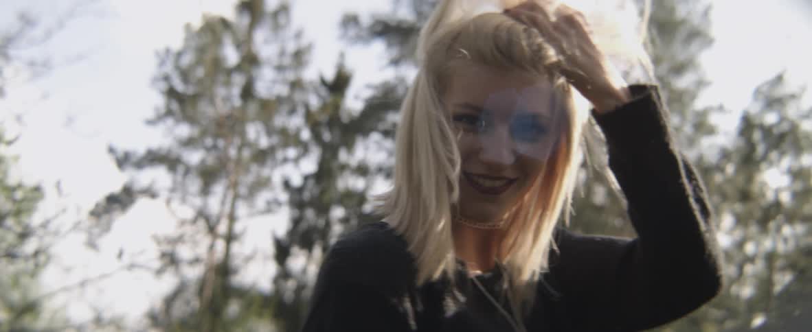 A woman turns around brushing her hair back and smiling