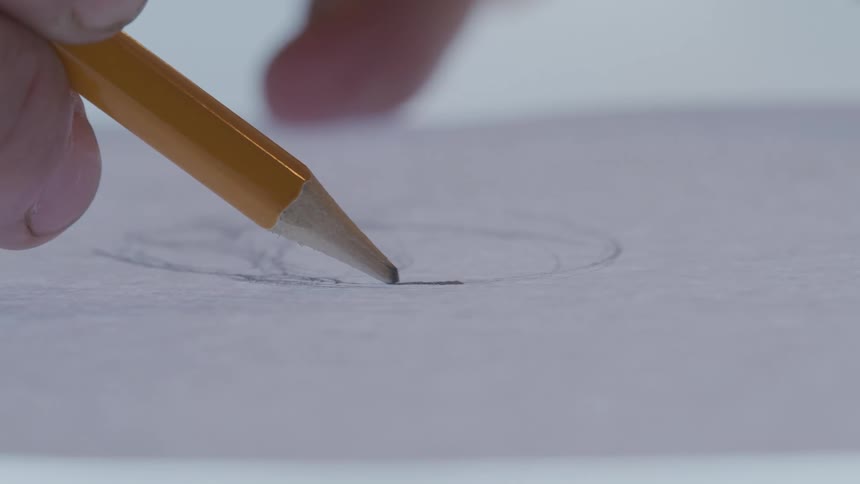 Closeup of a hand holding a pencil and drawing on paper