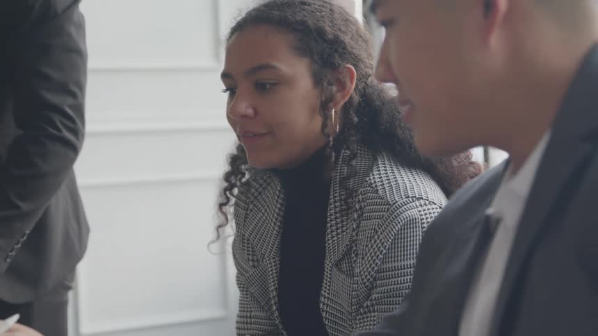 Coworkers having a discussion in a white paneled office